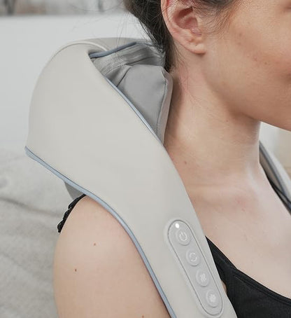 Woman using a neck and shoulder massager in a home setting